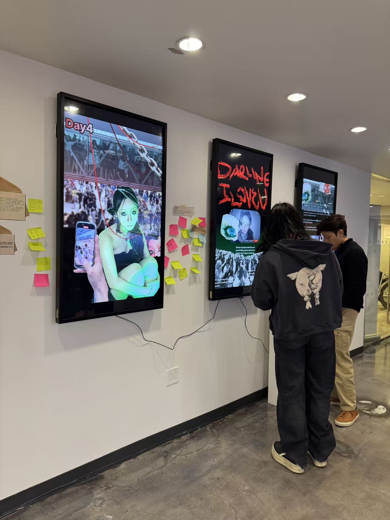 Visitors standing at Day 4 screens reading diary entries